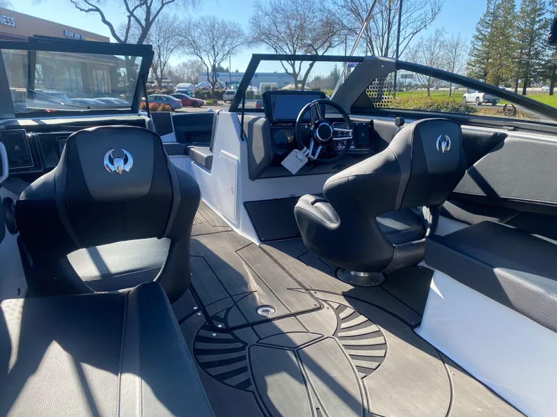 Slide: The Image of 2025 Scarab 235 LX Wake boat interior with sleek black seating and modern dashboard. - 22