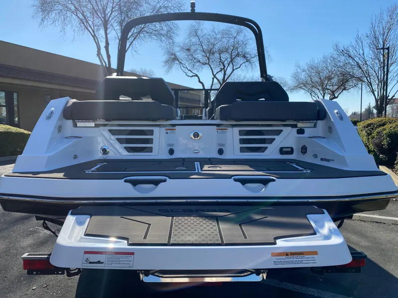 Slide: The Image of 2025 Scarab 235 LX Wake boat, rear view, showcasing sleek design and seating. - 3
