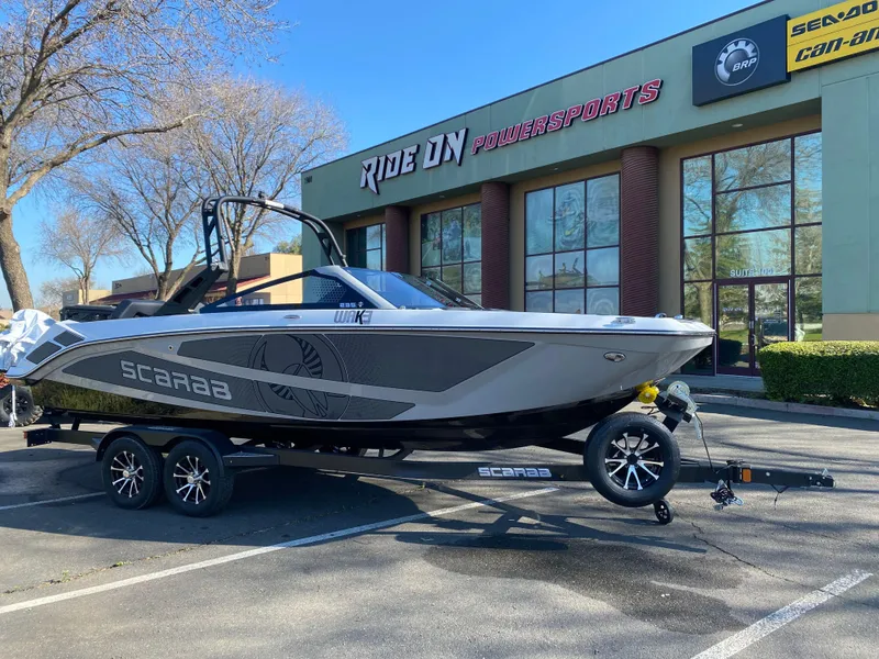 Slide: The Image of 2025 Scarab 235 LX Wake boat on trailer outside Ride On Powersports. - 4