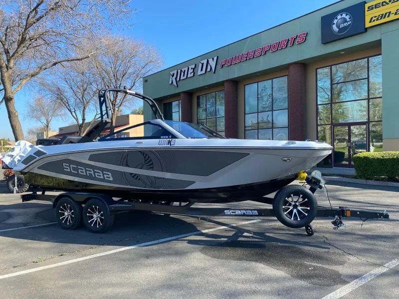 Slide: The Image of 2025 Scarab 235 LX Wake boat on trailer outside Ride On Powersports. - 5