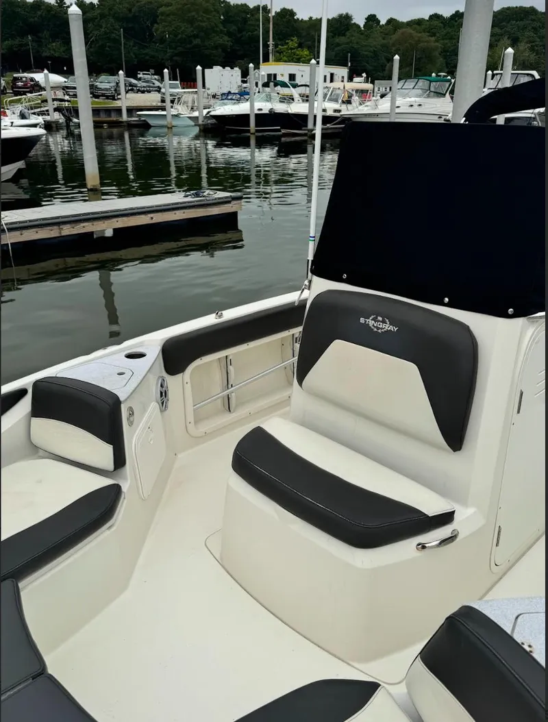Slide: The Image of 2018 Stingray 206 CC boat interior with seating, docked at marina. - 8