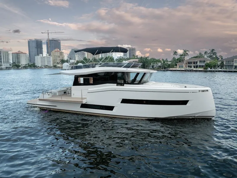 Slide: The Image of 2022 Pardo Yachts E60 luxury yacht on water with city skyline backdrop. - 1