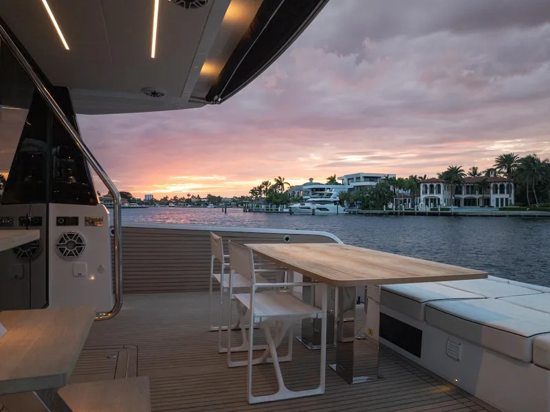 Slide: The Image of Luxurious 2022 Pardo Yachts E60 deck at sunset, overlooking serene waterfront homes. - 19