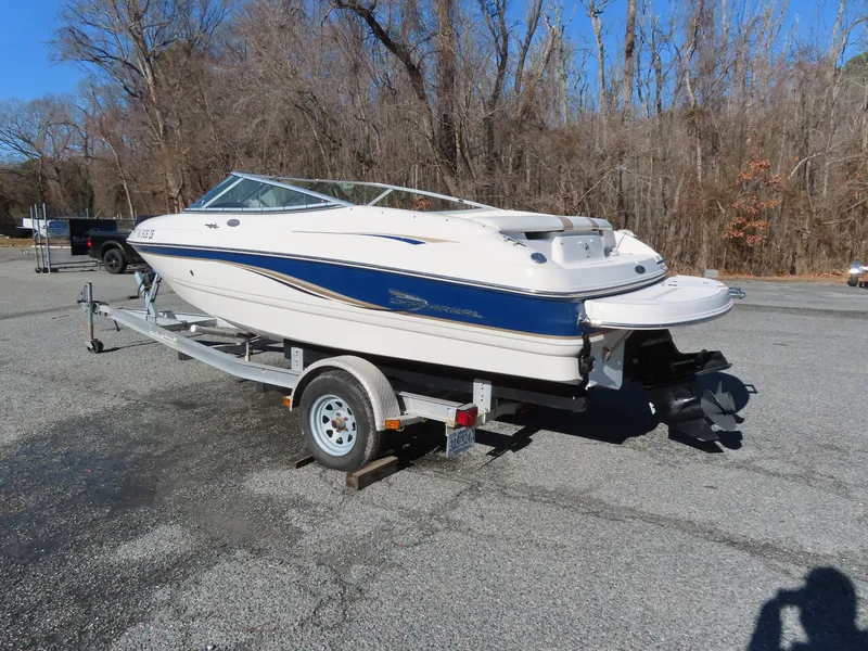 Slide: The Image of 2004 Chaparral 190 SSi boat on trailer in parking lot, surrounded by trees. - 2