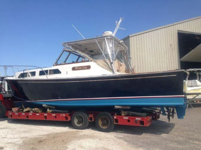 Slide: The Image of 1997 Fortier 33 HT Express boat on trailer near a warehouse. - 15