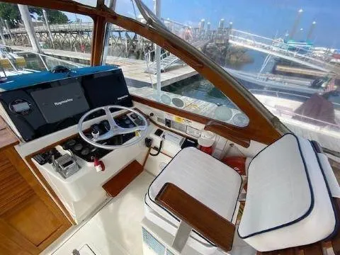 Slide: The Image of Interior helm of 1997 Fortier 33 HT Express boat with steering wheel and navigation equipment. - 16