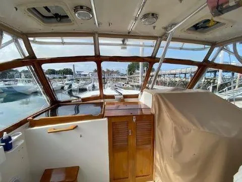 Slide: The Image of Interior view of 1997 Fortier 33 HT Express boat with wooden cabinetry and marina backdrop. - 18