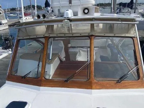 Slide: The Image of 1997 Fortier 33 HT Express boat docked at marina, featuring wooden trim and large windows. - 19