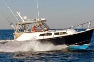 Slide: The Image of 1997 Fortier 33 HT Express boat cruising on open water. - 2