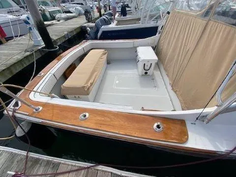 Slide: The Image of 1997 Fortier 33 HT Express boat with wooden deck and beige seating at a marina. - 21
