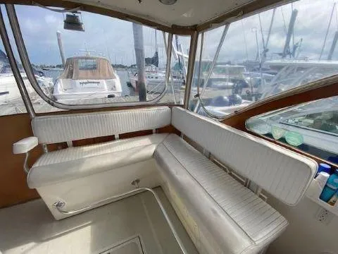 Slide: The Image of Interior of 1997 Fortier 33 HT Express boat with white seating and marina view. - 23