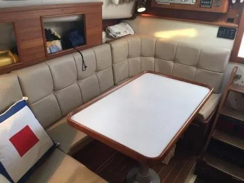 Slide: The Image of 1997 Fortier 33 HT Express cabin interior with cushioned seating and table. - 24