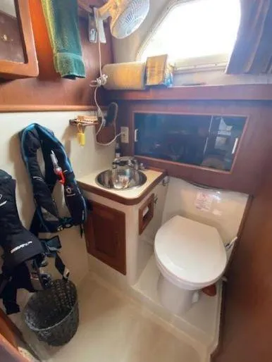 Slide: The Image of 1997 Fortier 33 HT Express boat bathroom with sink, toilet, and storage. - 27