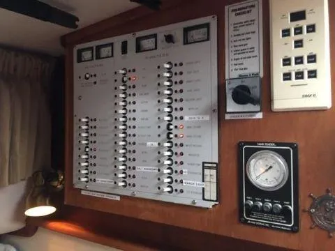 Slide: The Image of Control panel inside 1997 Fortier 33 HT Express boat, featuring switches and gauges. - 33