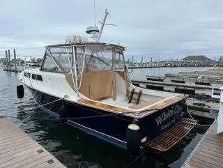 Slide: The Image of 1997 Fortier 33 HT Express boat docked at marina, rear view. - 5