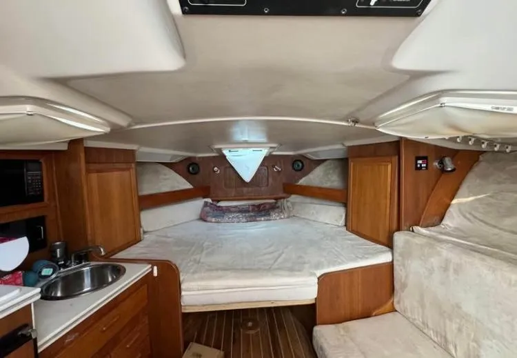 Slide: The Image of 1996 Luhrs Tournament 320 Open cabin interior with bed, kitchenette, and wood accents. - 4