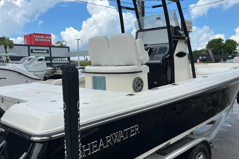 Slide: The Image of 2024 ShearWater 260 Carolina Flare boat displayed at dealership under blue sky. - 6
