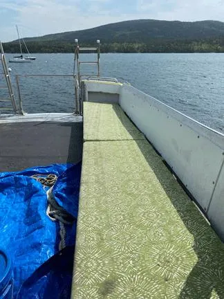 Slide: The Image of 1978 Marine Management Flybridge boat with green seating, docked on a serene lake. - 11