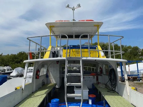 Slide: The Image of 1978 Marine Management Flybridge Commercial Passenger boat with upper deck and ladder, docked outdoors. - 5