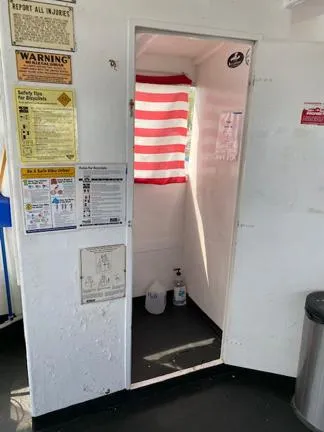 Slide: The Image of Interior of 1978 Marine Management Flybridge boat with safety notices and striped curtain. - 9