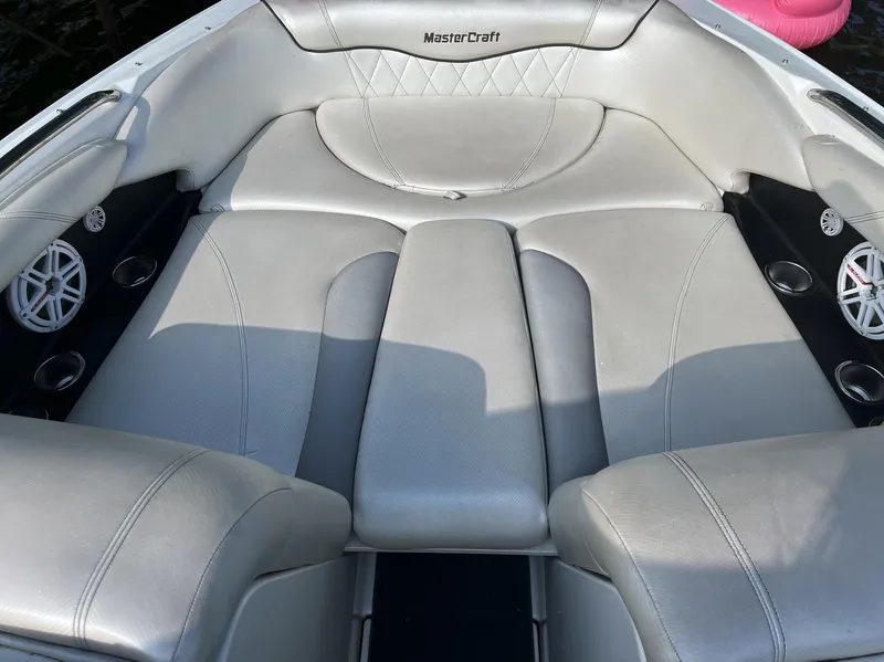 Slide: The Image of 2011 MasterCraft XStar boat interior with gray seating and cup holders. - 5