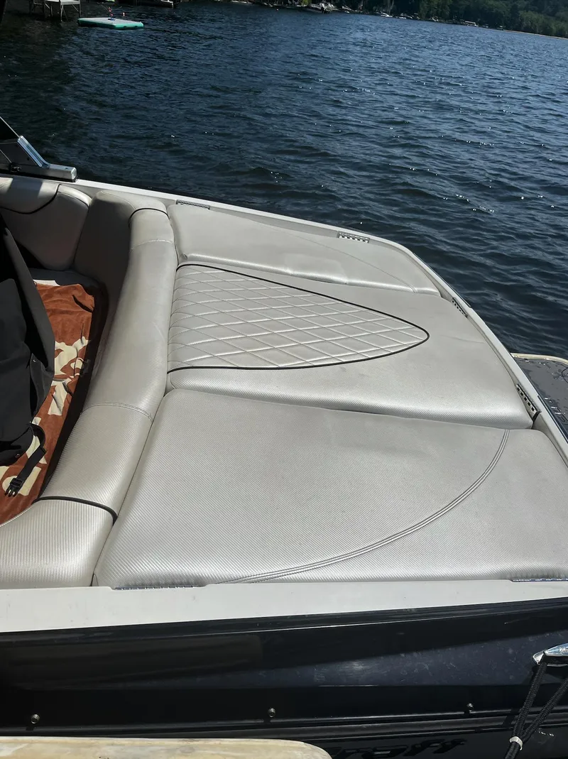 Slide: The Image of 2011 MasterCraft XStar boat with beige seating, docked on a sunny lake. - 7