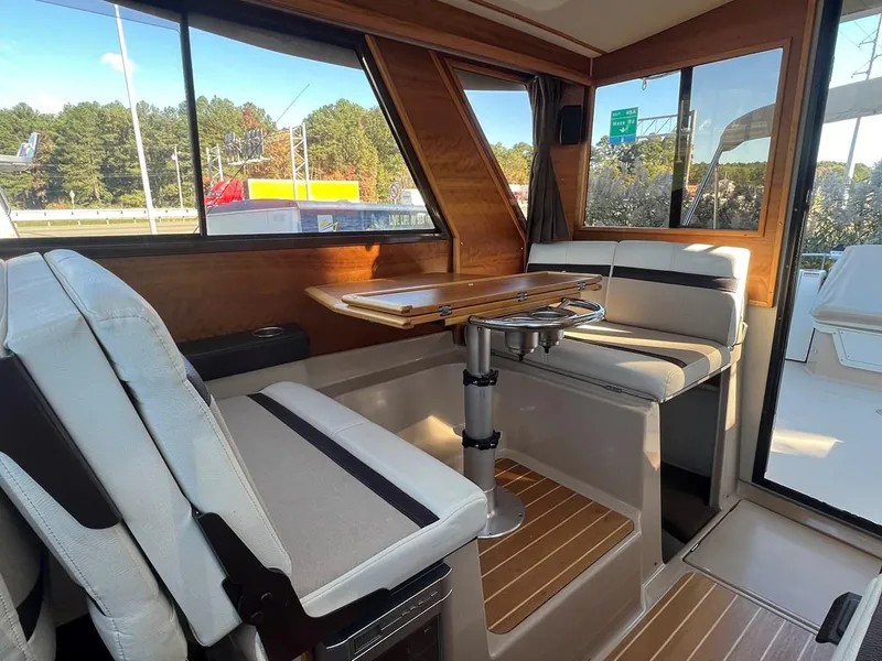 Slide: The Image of Interior of 2016 Cutwater C-28 boat with seating and table, featuring wood accents. - 23