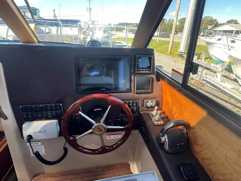Slide: The Image of 2016 Cutwater C-28 helm with Garmin navigation, wooden steering wheel, and control panel. - 25