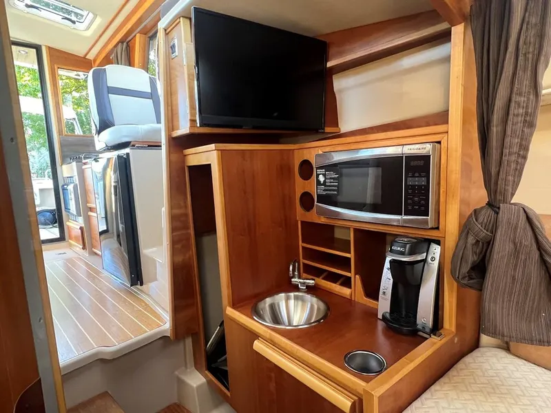 Slide: The Image of 2016 Cutwater C-28 interior with kitchenette, featuring microwave, sink, and coffee maker. - 41