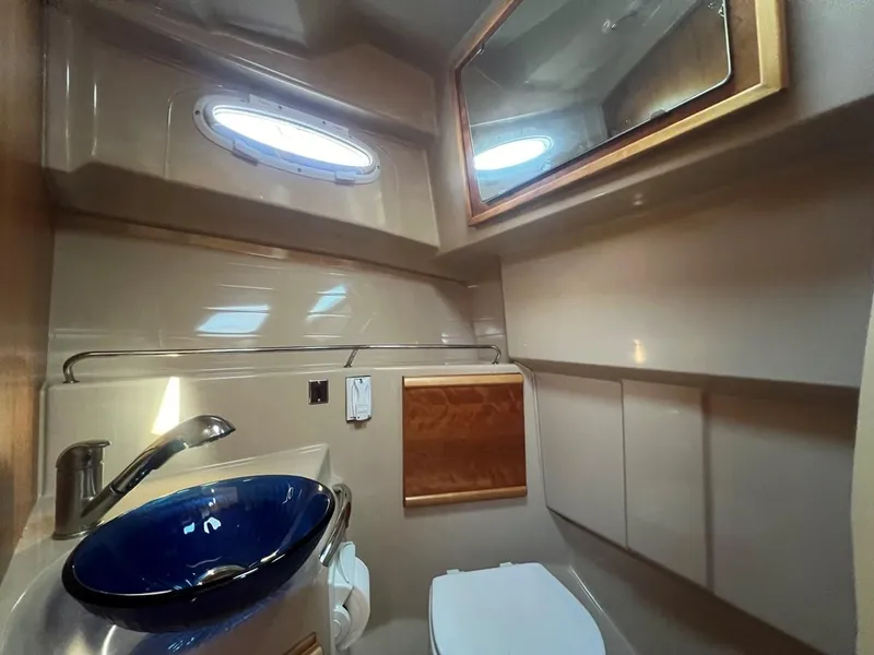 Slide: The Image of 2016 Cutwater C-28 boat bathroom with modern sink, mirror, and porthole window. - 47