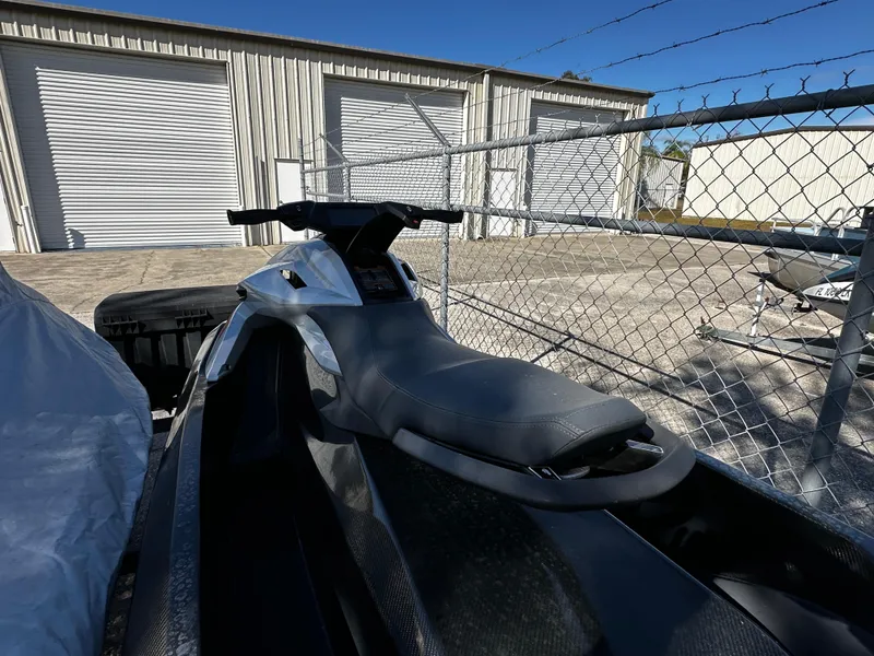Slide: The Image of 2022 Orca Carbon jet ski parked near a chain-link fence and storage units. - 5