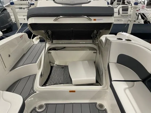 Slide: The Image of 2021 Chaparral 267 SSX OB boat with open storage compartment and cushioned seating. - 15