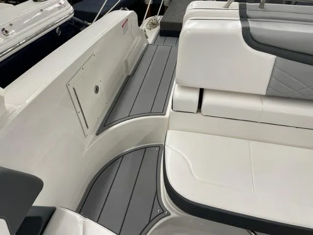 Slide: The Image of 2021 Chaparral 267 SSX OB boat interior with white and gray seating and flooring. - 16