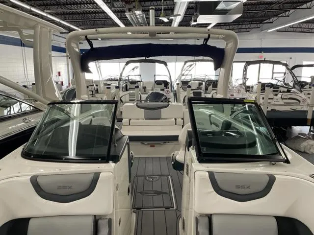 Slide: The Image of 2021 Chaparral 267 SSX OB boat interior in showroom, featuring sleek design and seating. - 6