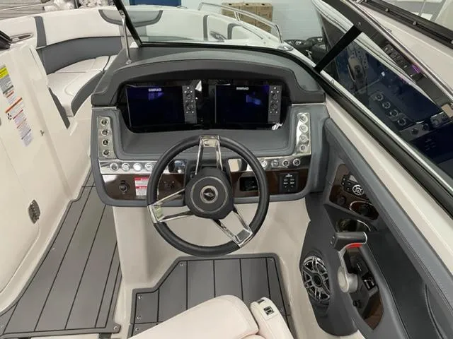 Slide: The Image of 2021 Chaparral 267 SSX OB boat dashboard with steering wheel and dual displays. - 8