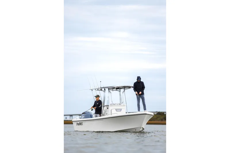 Slide: The Image of 2025 Parker 18SE Center Console boat cruising near a bridge on a cloudy day. - 4
