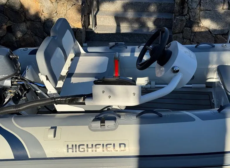 Slide: The Image of 2023 Highfield Classic 310 FCT boat with steering console and seating, docked outdoors. - 2