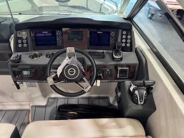 Slide: The Image of 2022 Chaparral 280 OSX boat dashboard with steering wheel and navigation controls. - 12
