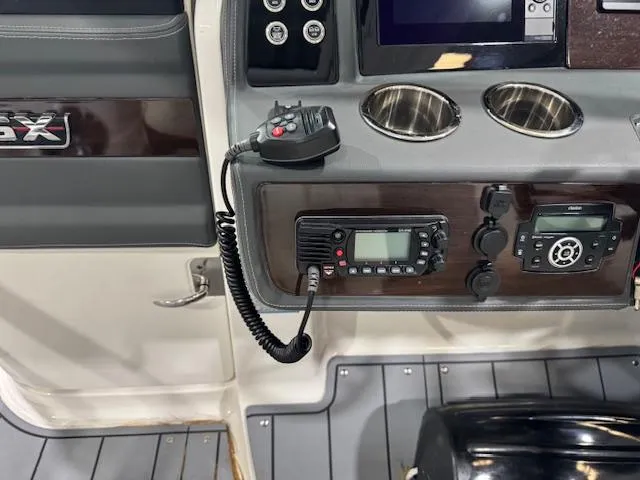 Slide: The Image of 2022 Chaparral 280 OSX boat dashboard with radio controls and cup holders. - 15