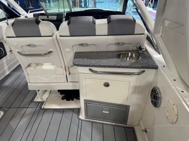 Slide: The Image of 2022 Chaparral 280 OSX boat interior with seating and kitchenette area. - 21