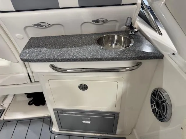 Slide: The Image of 2022 Chaparral 280 OSX boat interior with sink and storage cabinet. - 22