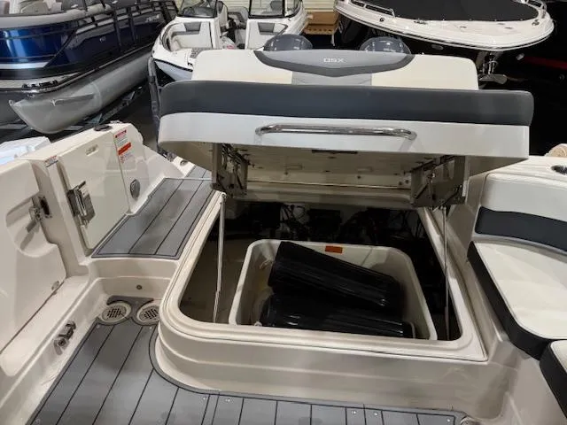 Slide: The Image of 2022 Chaparral 280 OSX boat with open storage compartment, showcasing sleek interior design. - 23