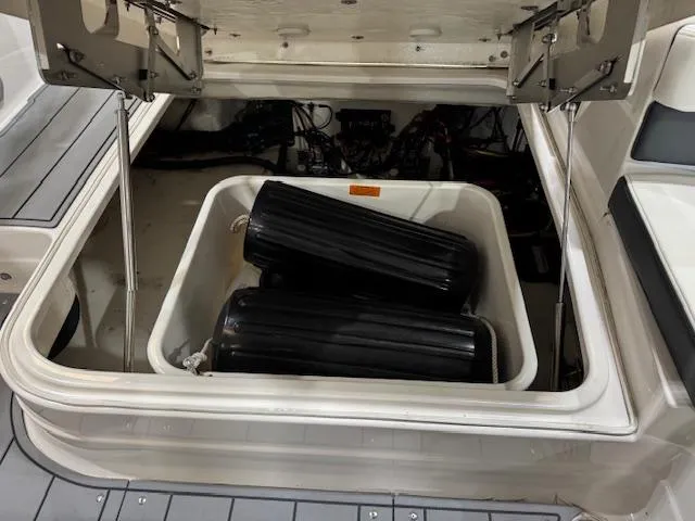 Slide: The Image of 2022 Chaparral 280 OSX boat storage compartment with black fenders. - 24