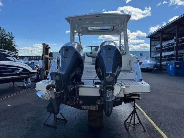 Slide: The Image of 2022 Chaparral 280 OSX boat with dual outboard motors in a marina setting. - 3