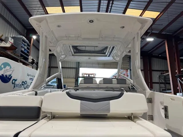 Slide: The Image of 2022 Chaparral 280 OSX boat interior in a showroom, featuring sleek seating and modern design. - 32