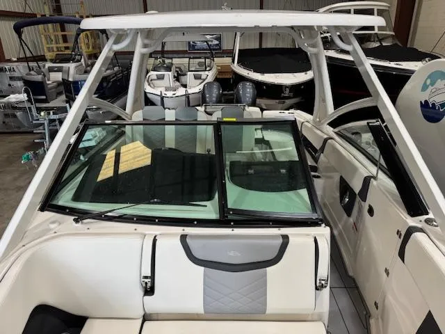 Slide: The Image of 2022 Chaparral 280 OSX boat interior with seating and windshield in a showroom. - 9