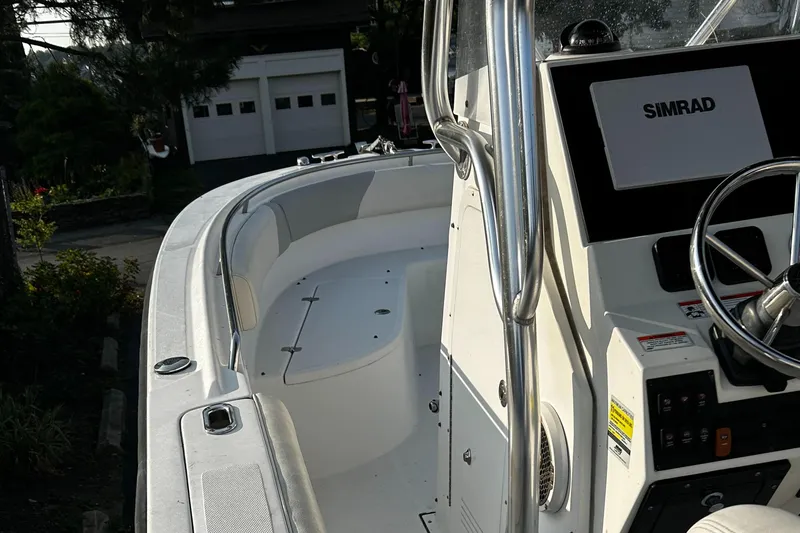 Slide: The Image of 2010 Edgewater 228CC boat with Simrad navigation system, parked near a garage. - 10