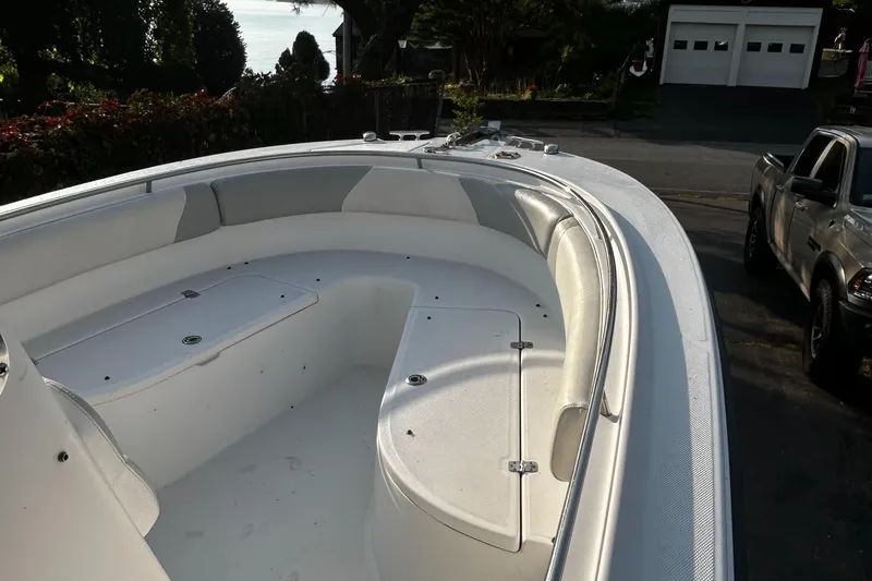 Slide: The Image of 2010 Edgewater 228CC boat with spacious seating and storage, parked outdoors. - 13