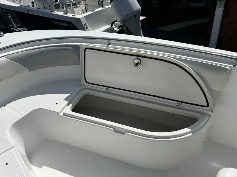 Slide: The Image of Open storage compartment on a 2010 Edgewater 228CC boat, featuring a sleek white design. - 17