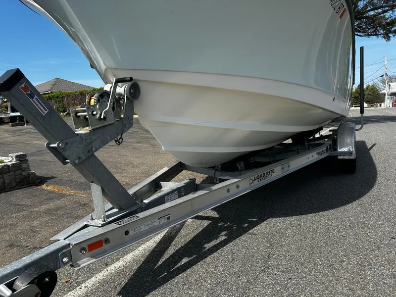 Slide: The Image of 2010 Edgewater 228CC boat on trailer, parked on asphalt under clear sky. - 20